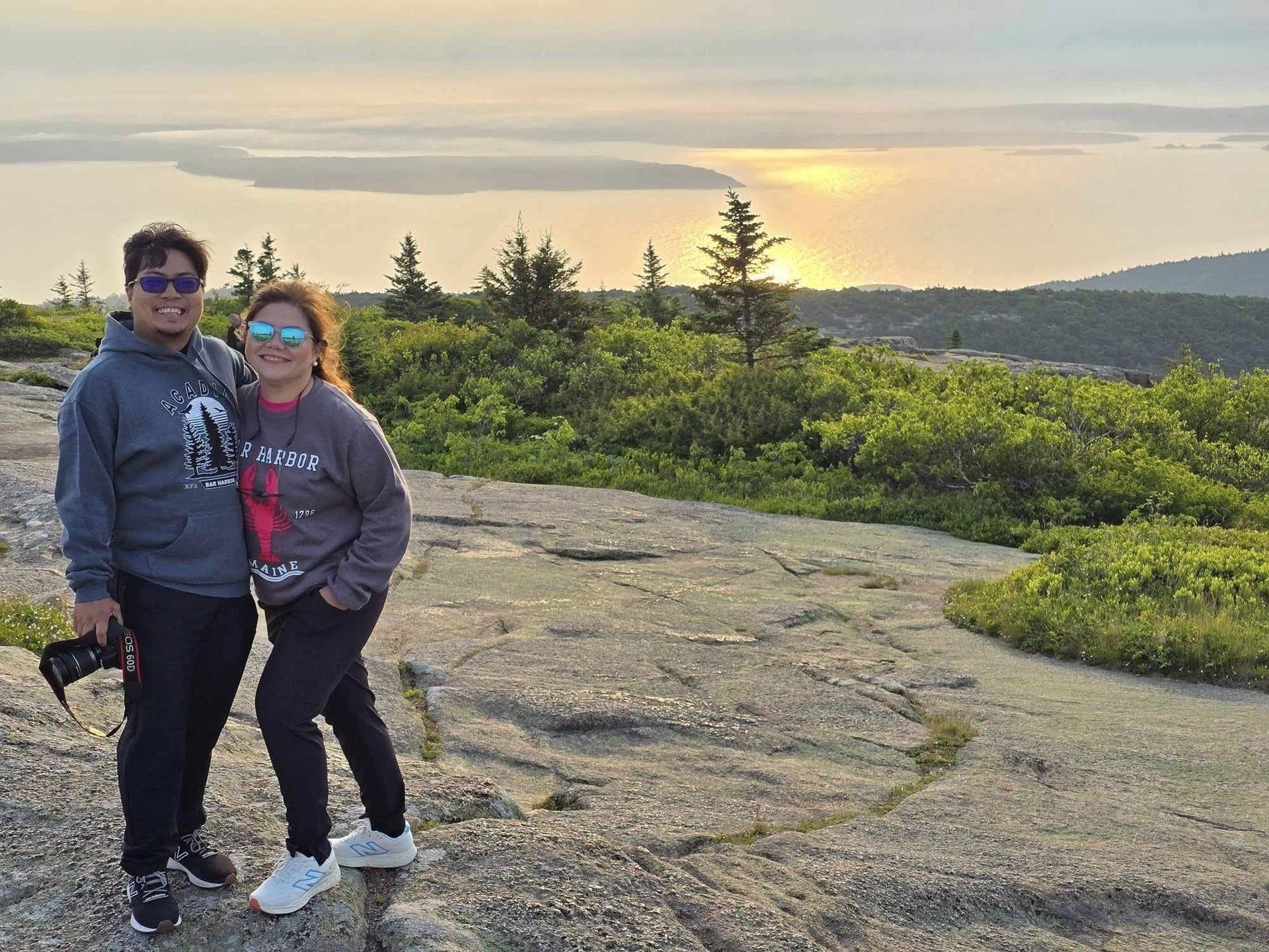 Rochelle and Nathaniel on the granite coast of Acadia National Park at dusk