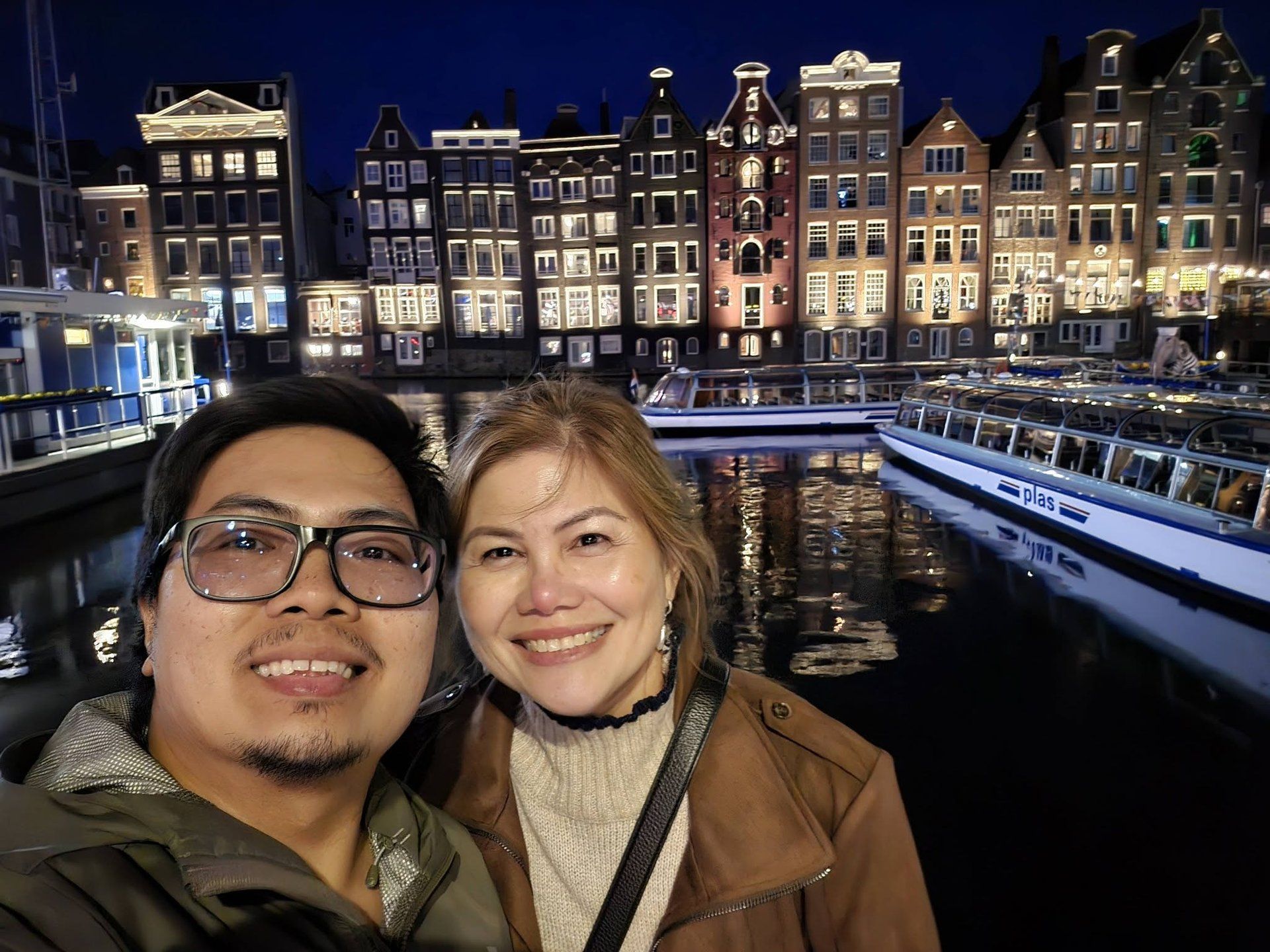 Rochelle and Nathaniel along a lit canal in Amsterdam at night