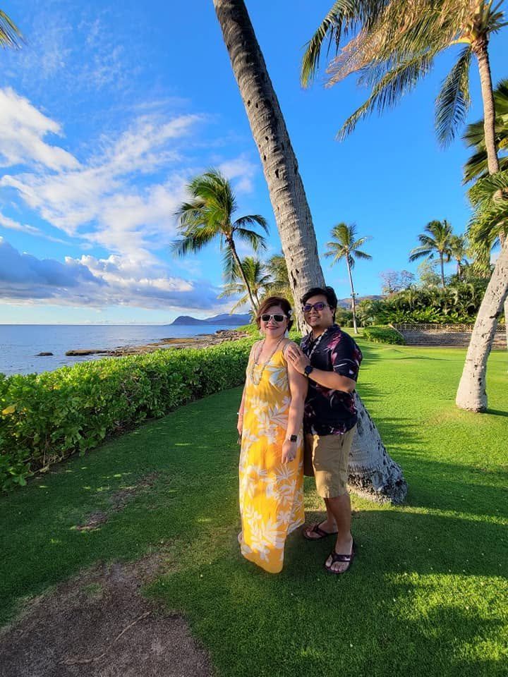 Rochelle and Nathaniel beneath palm trees at sunset in Hawaii