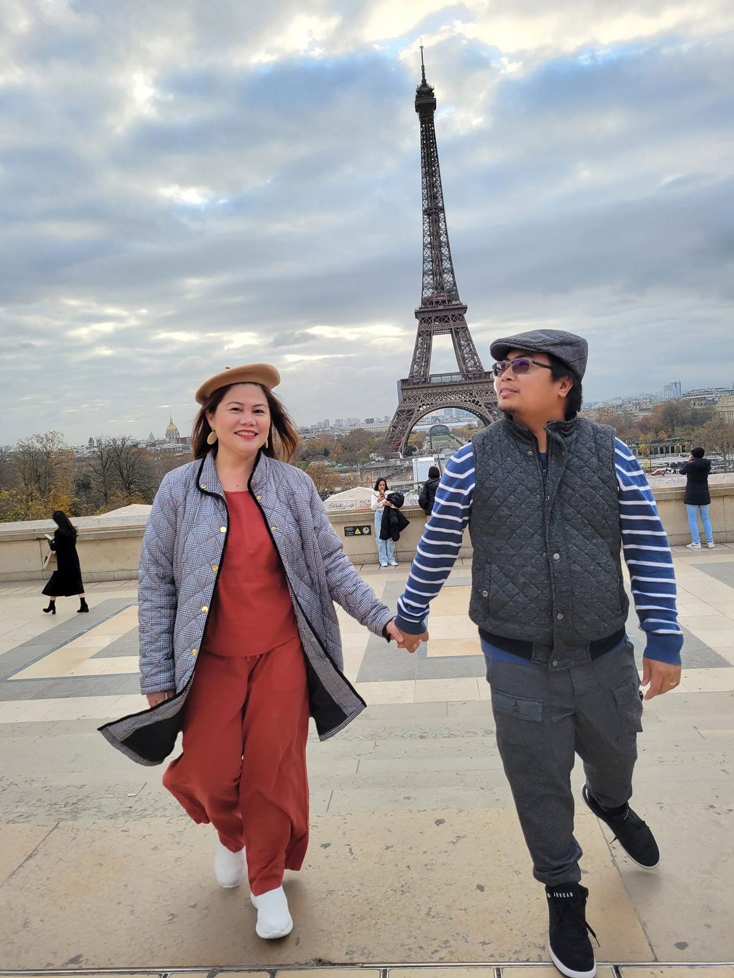Rochelle and Nathaniel walking hand in hand toward the Eiffel Tower