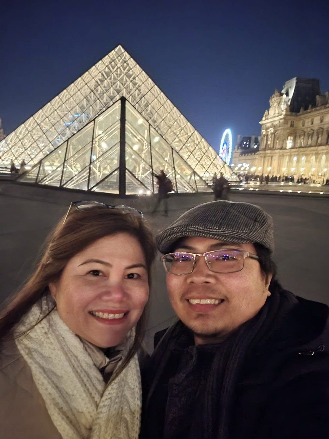 Rochelle and Nathaniel at the Louvre pyramid lit up at night